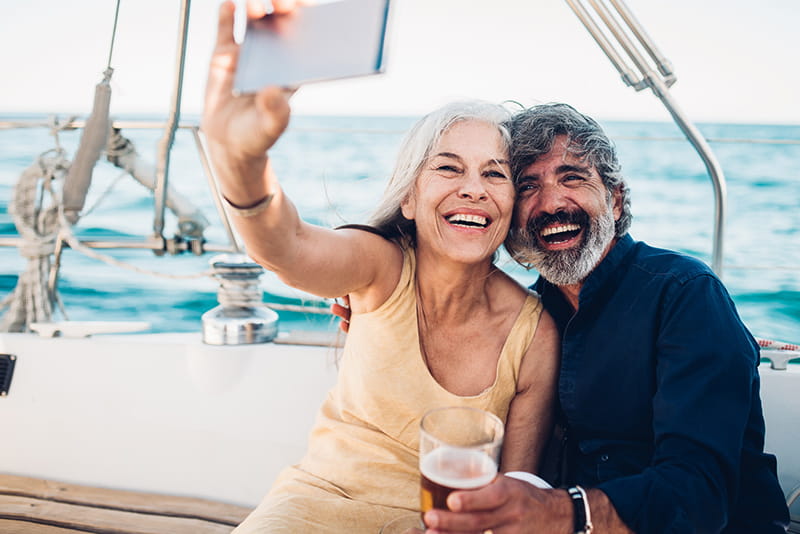happy couple on sailboat taking selfie