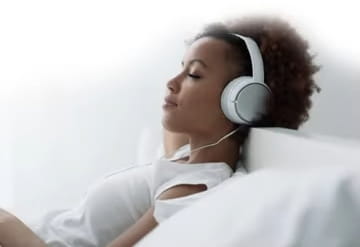 Women napping in bed with headphones on