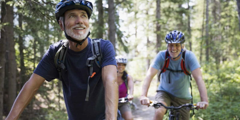 Older couple riding bikes on a trail