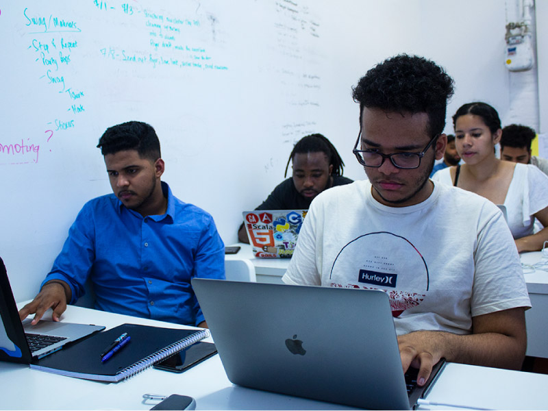 The Knowledge House students pore over tech lessons in class. (Photo courtesy of The Knowledge House)