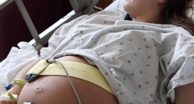 Pregnant woman in hospital bed with fetal monitor