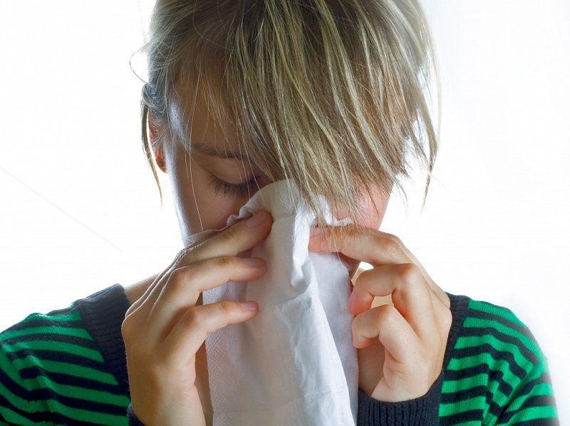 woman blowing her nose flu