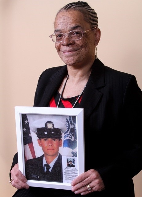 Heart transplant recipient Roxanne Watson, holding a photo of her heart donor, Michael Bovill.