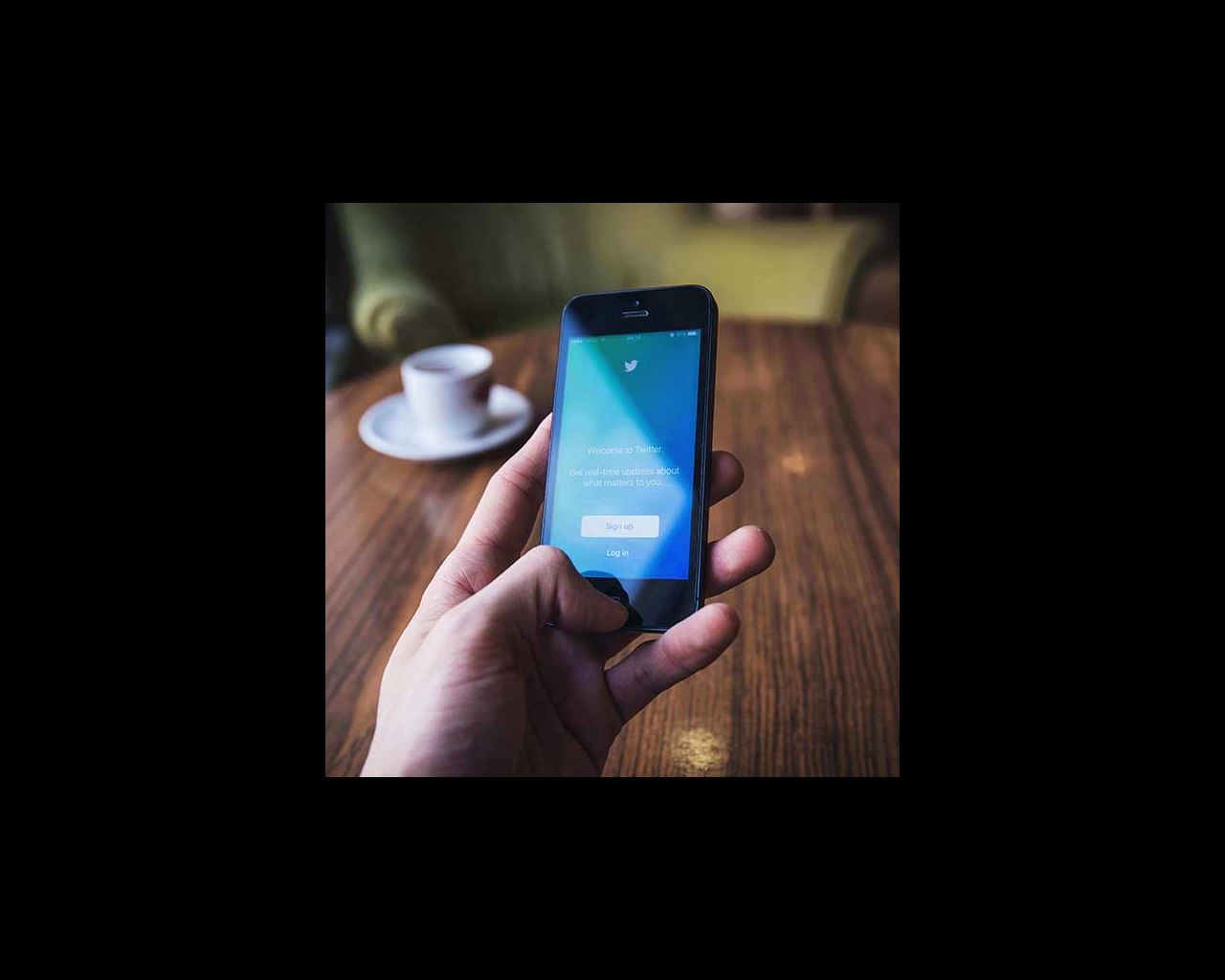 Person looks at Twitter on their cellphone