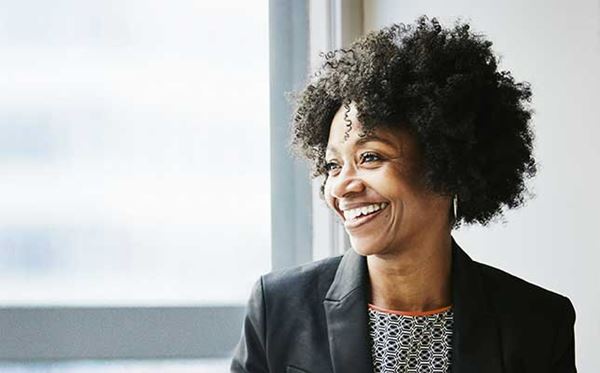 Smiling business woman in front of sunny window