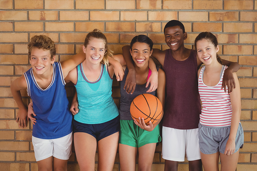 Students against a wall with basketball